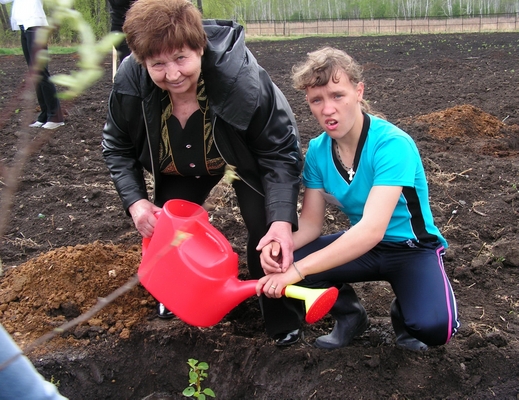 Анна Дмитриевна Дядикова вместе с воспитанницей школы-интернат садят яблоньку