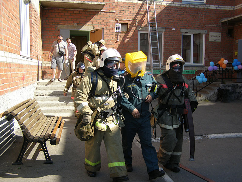  Пожарные выводят людей из «охваченного огнем» здания
