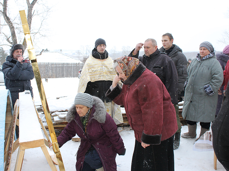 Люди прикладывались к кресту и молились перед тем, как он был установлен на купол