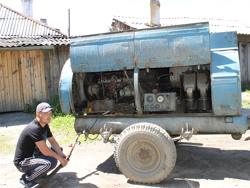 Компрессорщик Андрей Гурьянов подготавливает оборудование для промывки и опрессовки внутридомовых систем отопления