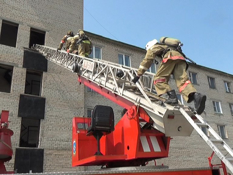 Пожарные поднимаются по автолестнице на 4-й этаж учебной башни