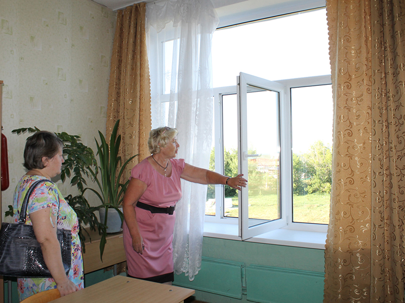 Директор школы Татьяна Егоровна Ежова показывает установленные новые окна в одном из учебных кабинетов