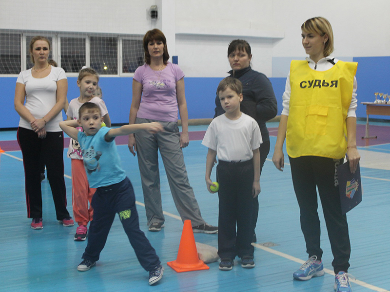 Татьяна Зацепина принимает у детей нормативы по метанию теннисного мяча в цель