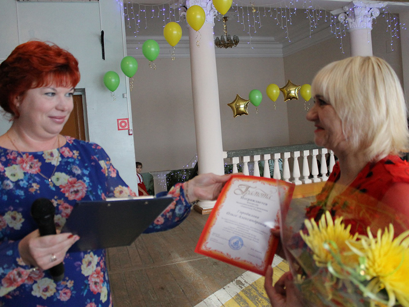 Марина Денисова вручает грамоту контролеру кинотеатра Ольге Городиловой