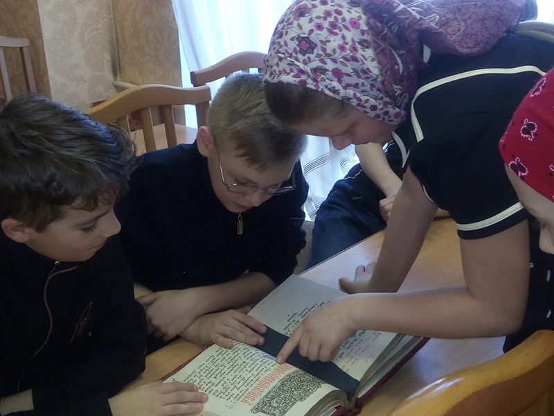 Ребята с интересом рассматривают православную книгу