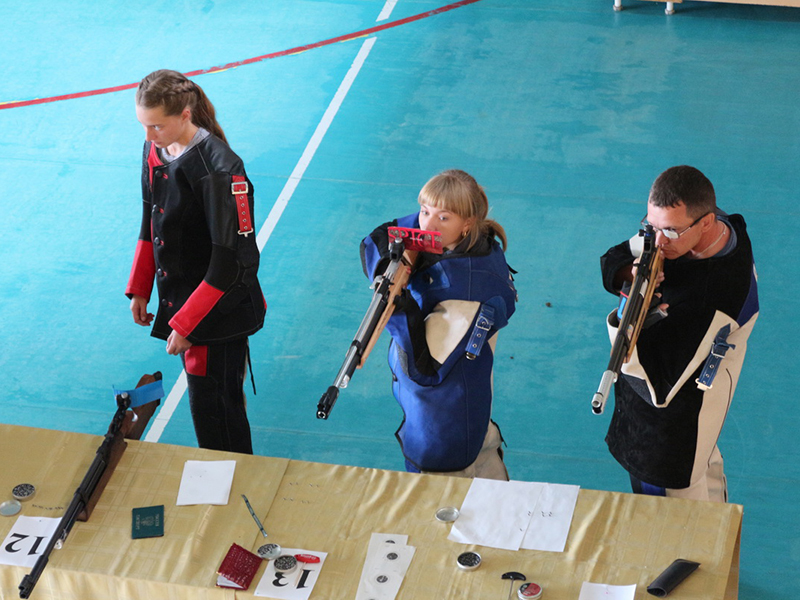 Ангелина Сенькина (в центре) выполняет стрельбу из пневматической винтовки