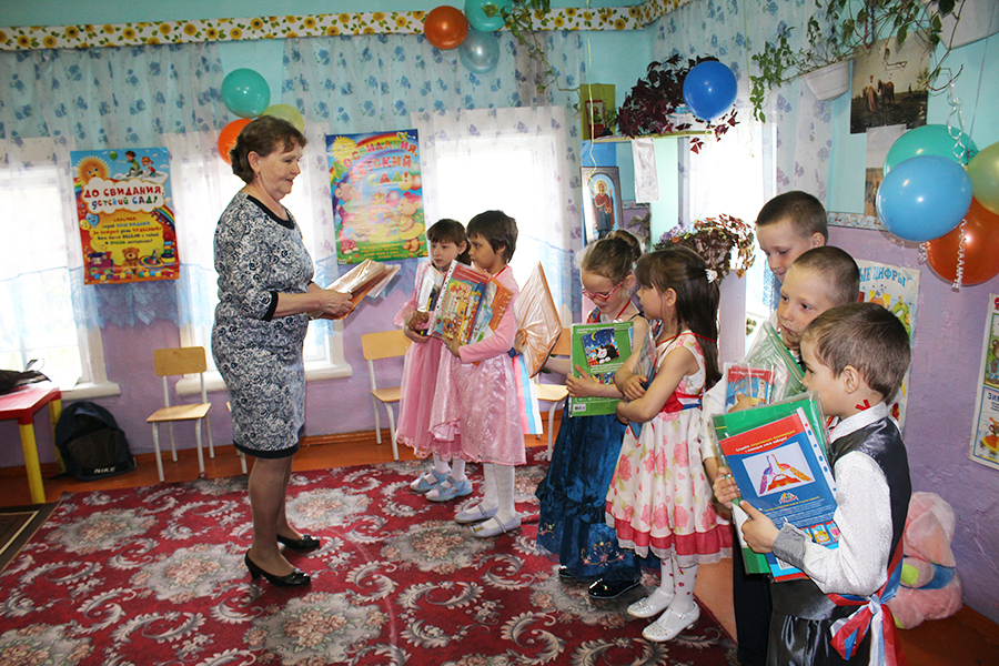 Воспитатель Татьяна Михайловна Вуколова вручает своим выпускникам подарки