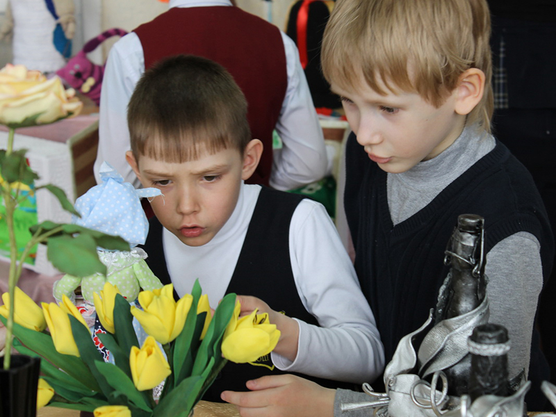 Мальчики с неподдельным удивлением разглядывают тюльпаны, которые так похожи на живые