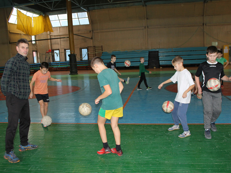 Сергей Булдаков ведет занятие-тренировку по футболу. Юные спортсмены отрабатывают навыки действий с мячом