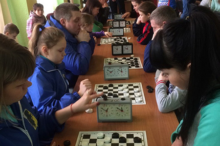 Участники соревнований спортивных семей (слева): Наталья, Полина и Дмитрий Ивановы состязаются в шашечном туре